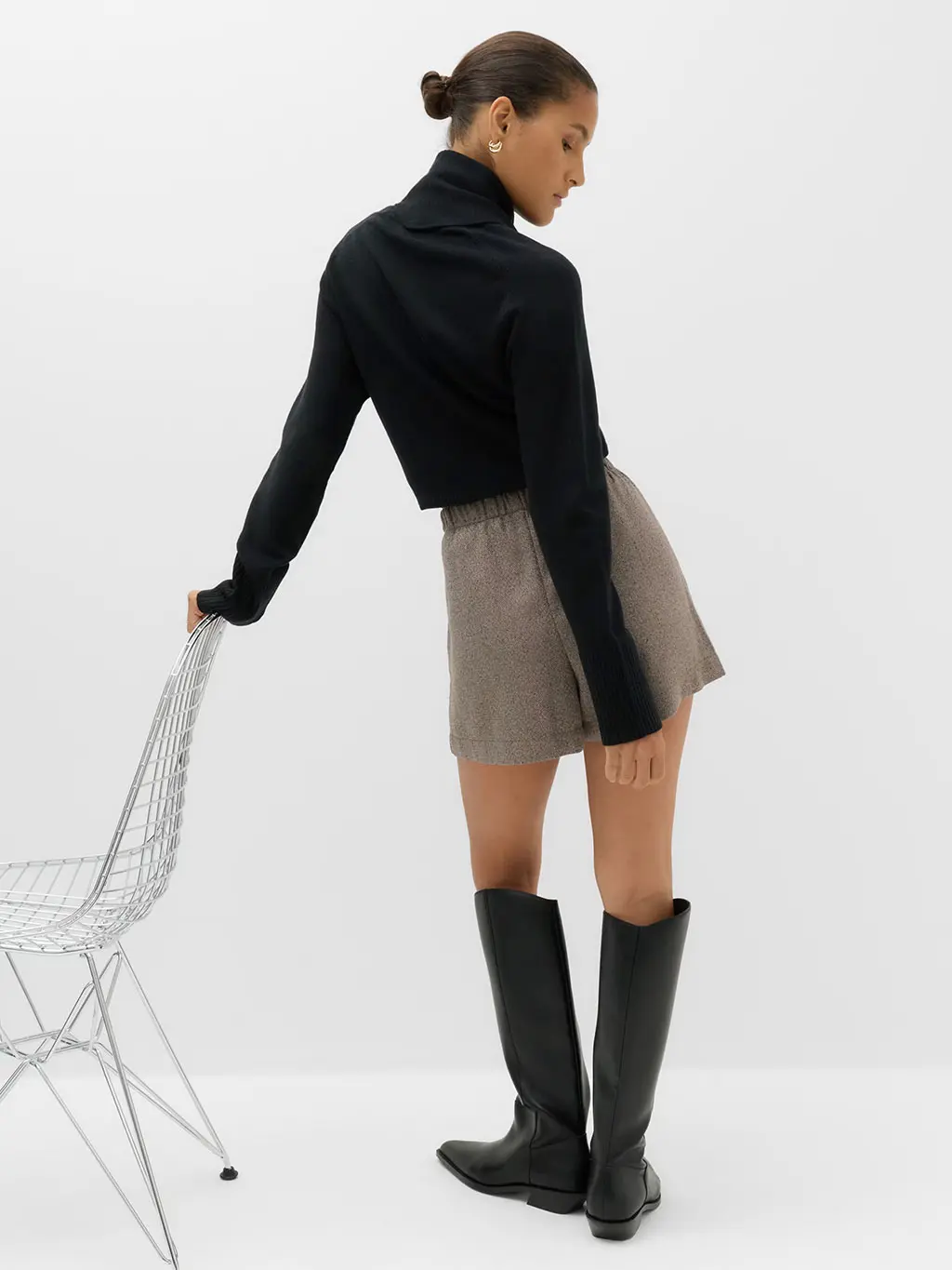 Woman in jumper, shorts and boots