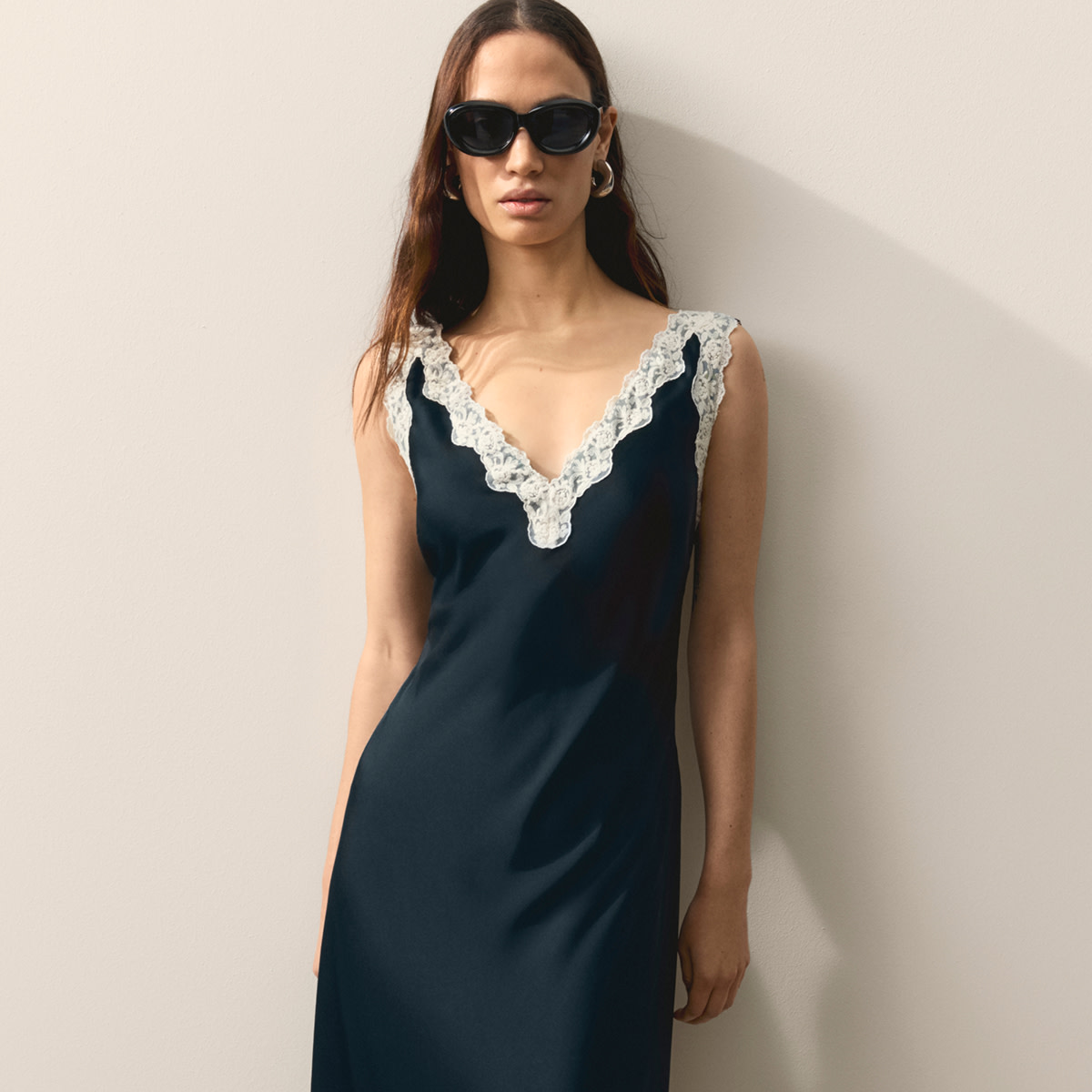 Woman wearing black dress with white lace detailing 