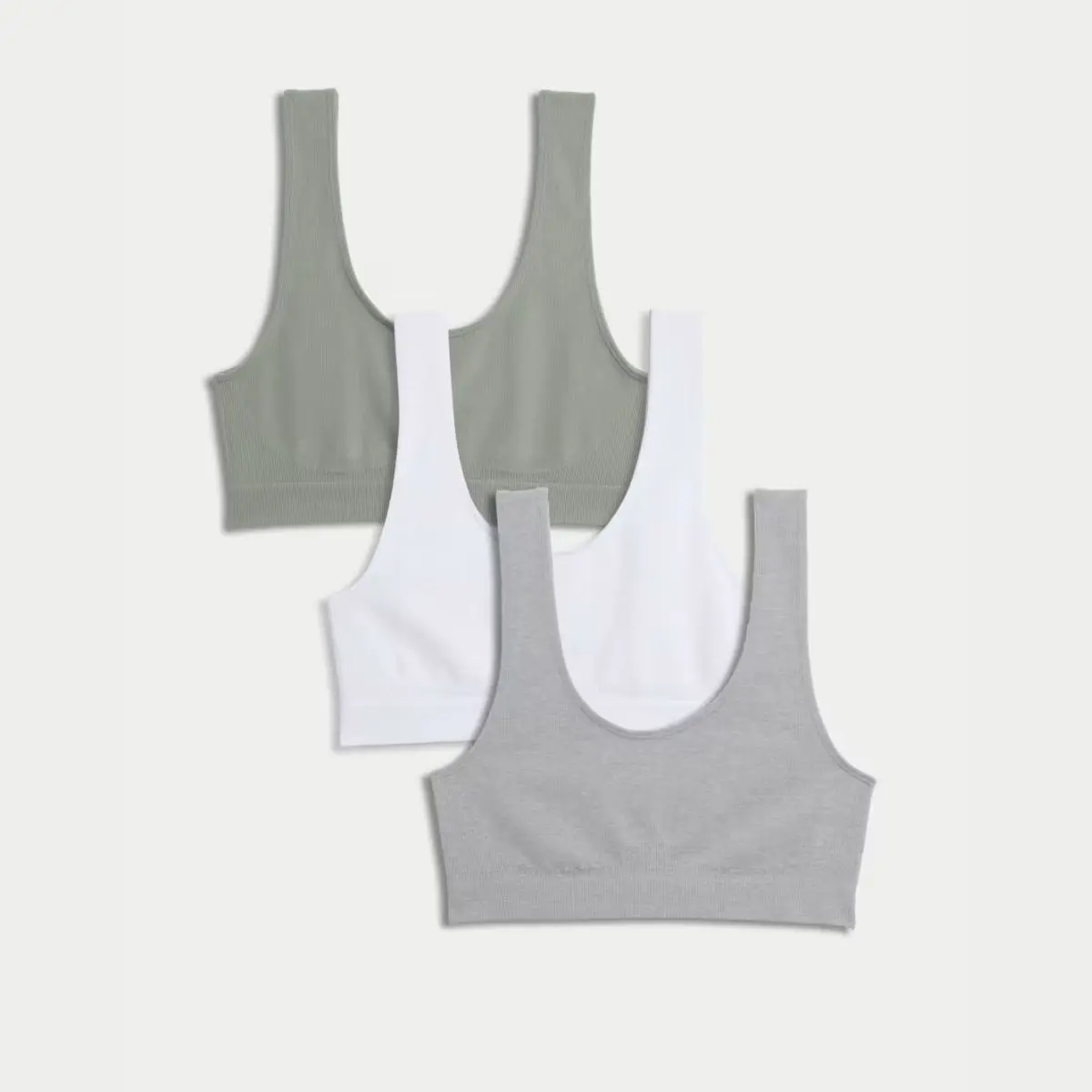 A shot of three seamless crop tops in green, white and grey by M&S