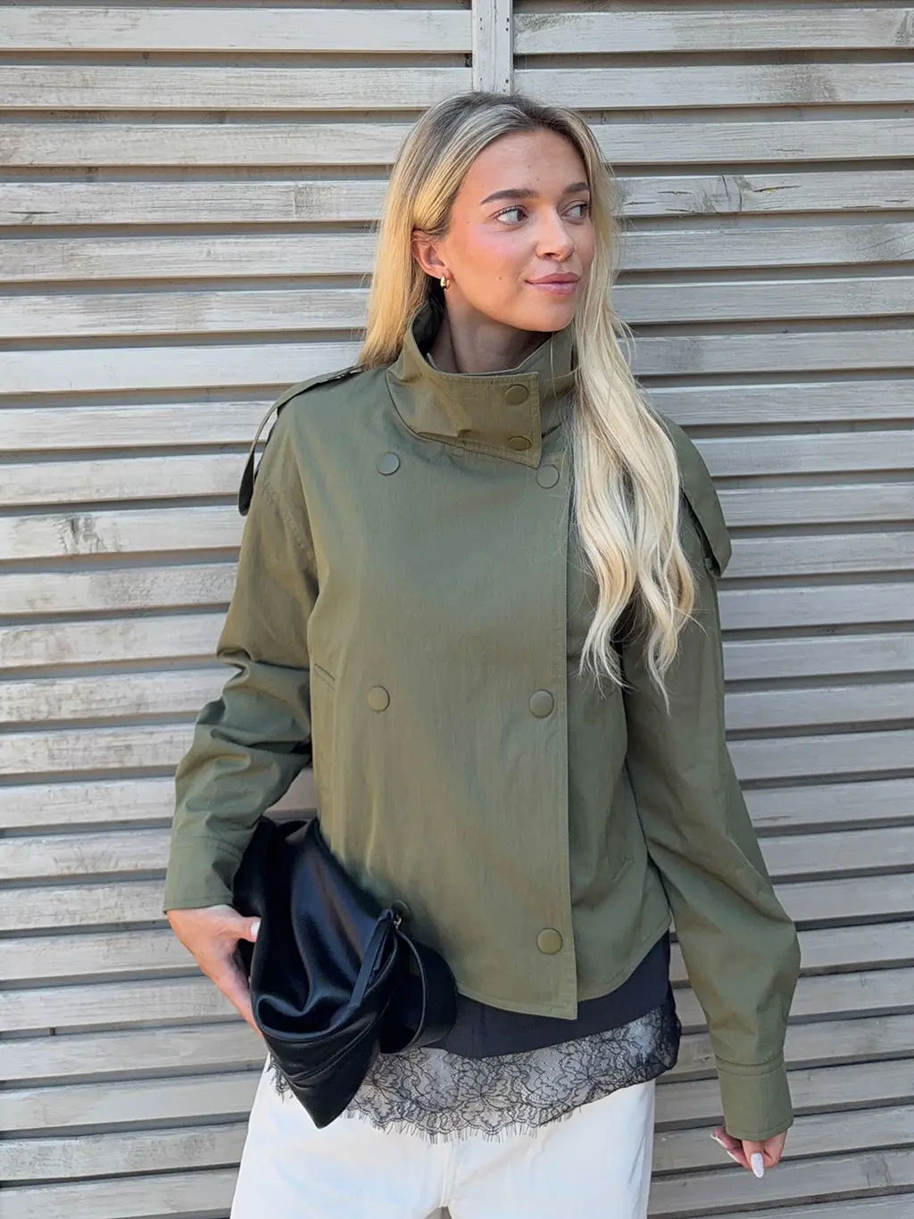 Woman in green jacket and white trousers