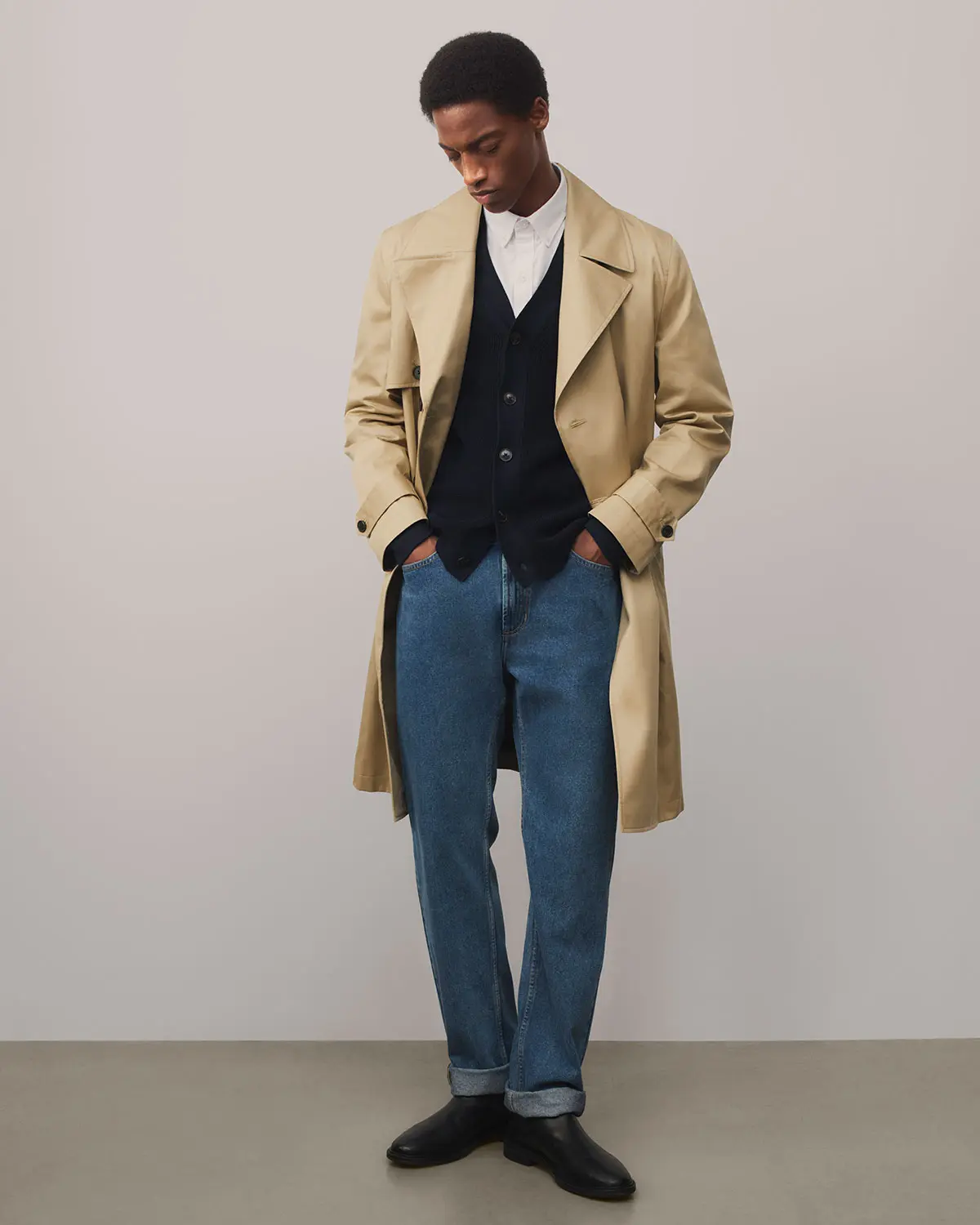 Man wearing blue jeans a trench coat at M&S