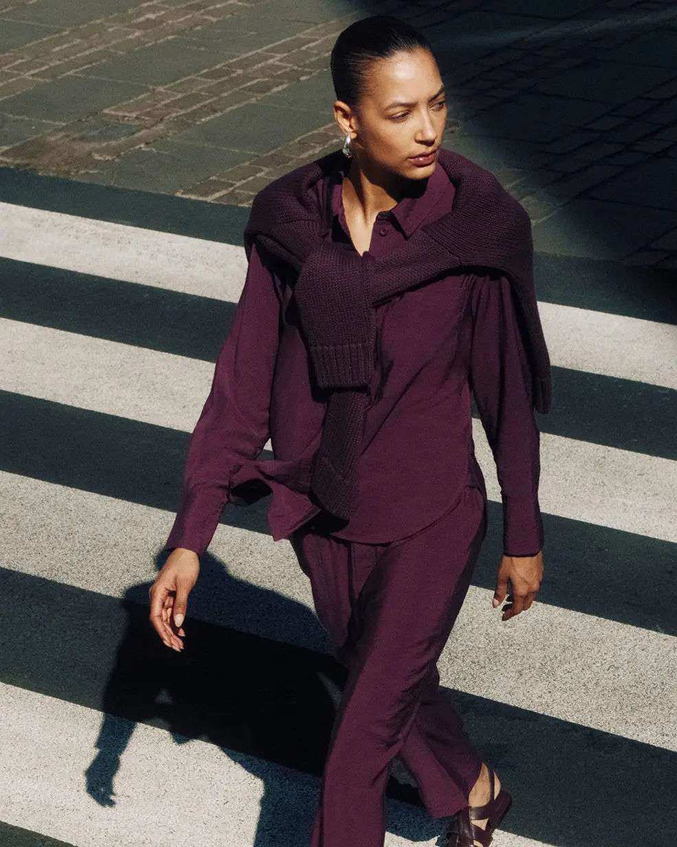 Woman wearing burgundy shirt and matching trousers from Hush at M&S