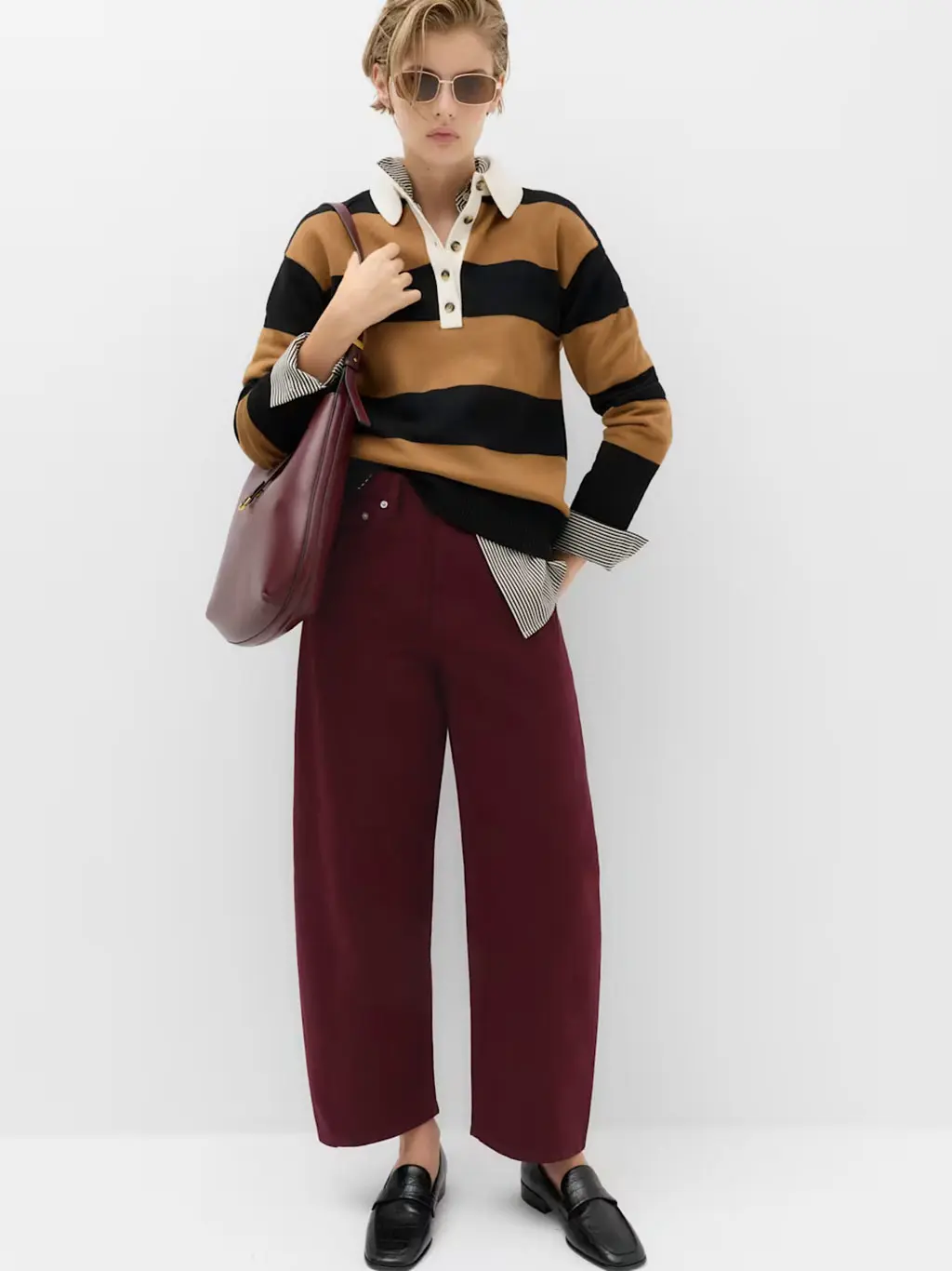 Woman in burgundy barrel jeans and rugby top