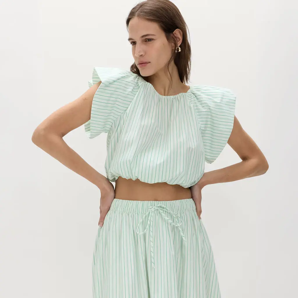 Woman wearing striped green two-piece set of a blouse and a skirt