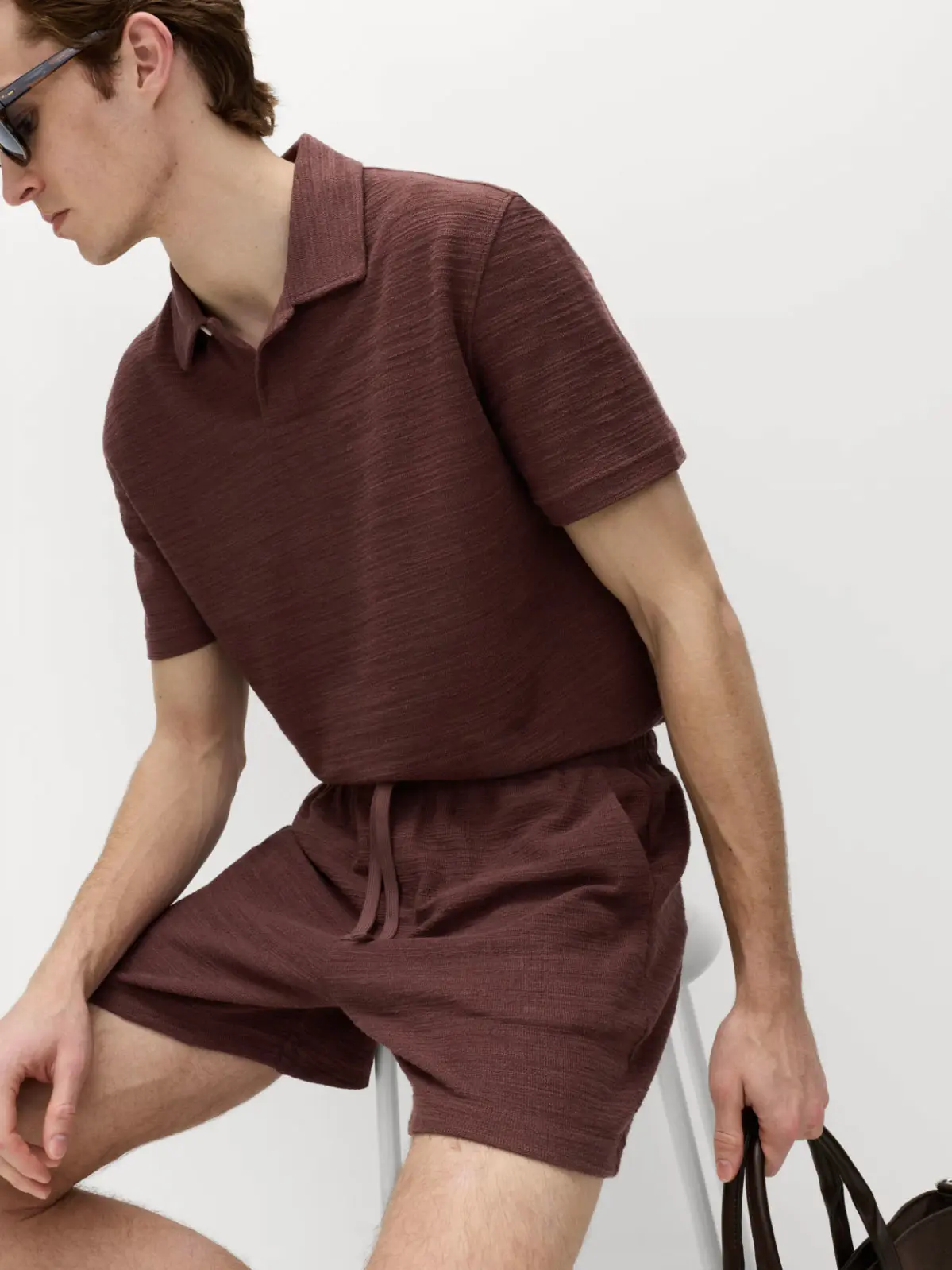 Man wearing brown polo top and matching brown shorts