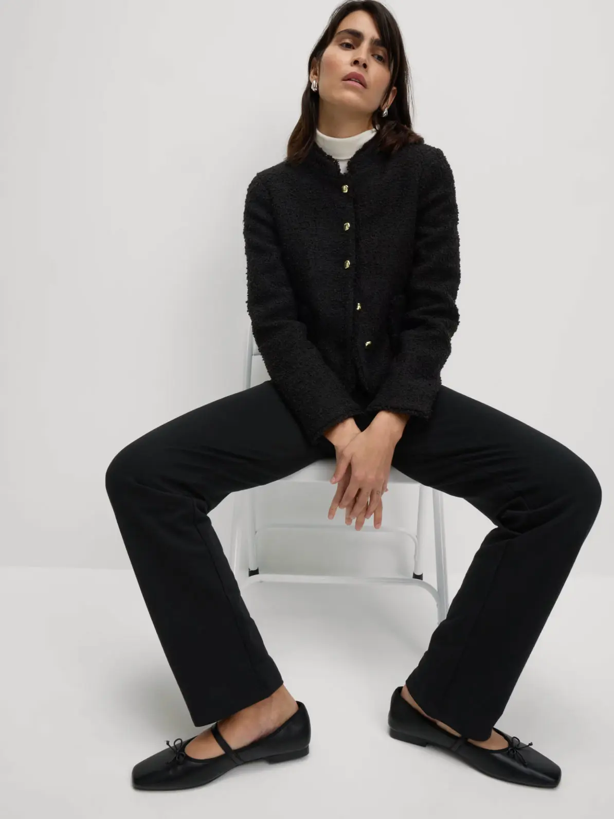 Woman wearing black joggers with a black jacket and black ballet flats