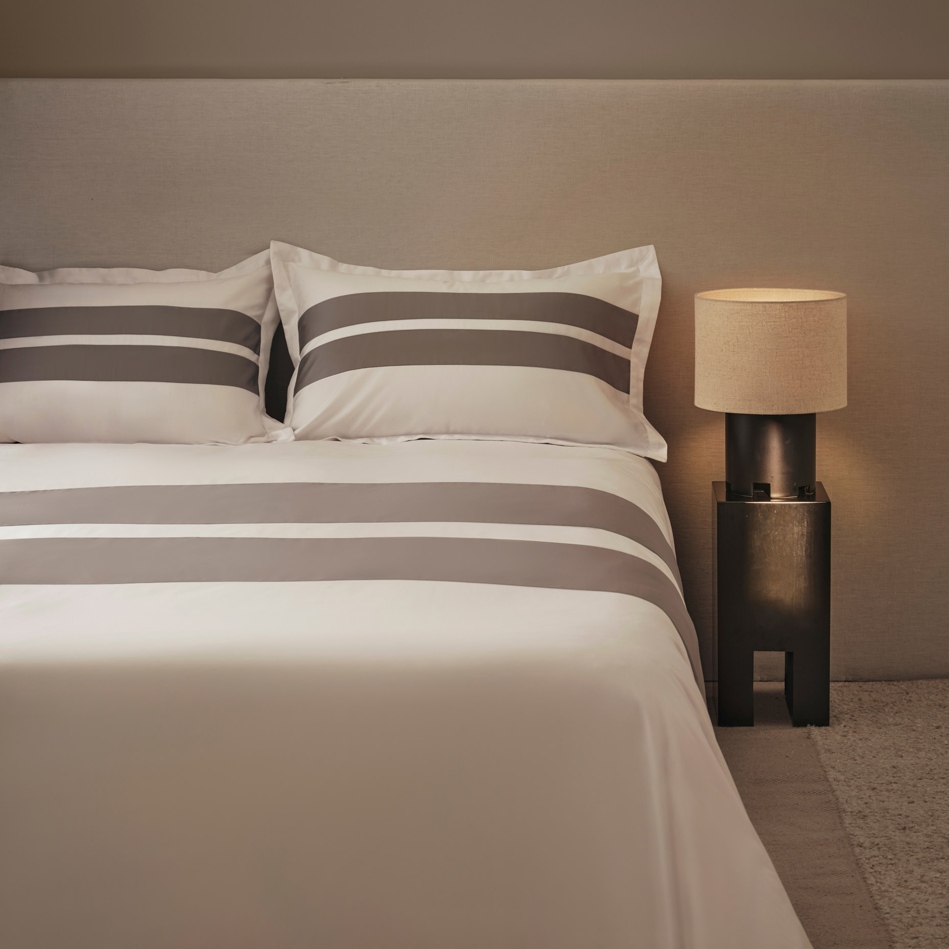 Bed with white and grey striped bedding