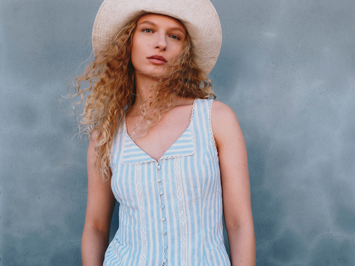 Woman wearing blue striped dress with hat