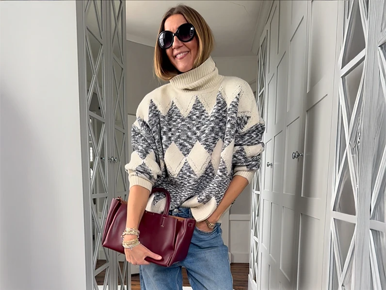 Influencer Hayley Karseras wearing an argyle roll-neck jumper with black sunglasses and a burgundy bag