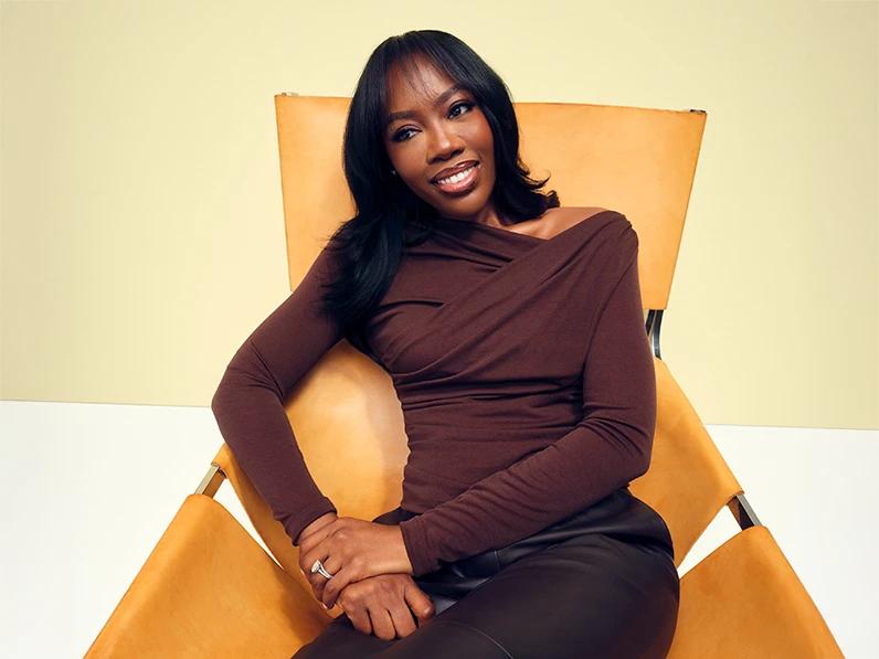 Celebrity stylist, Melissa, wearing a burgundy top against a yellow wall