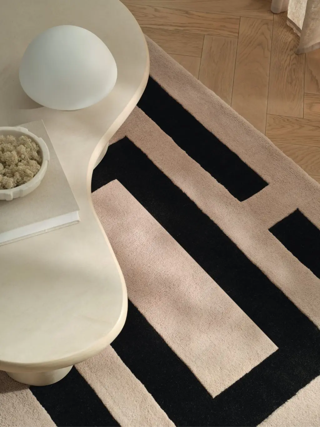 A Kelly Hoppen geometric run on the floor with a cream abstract table on top