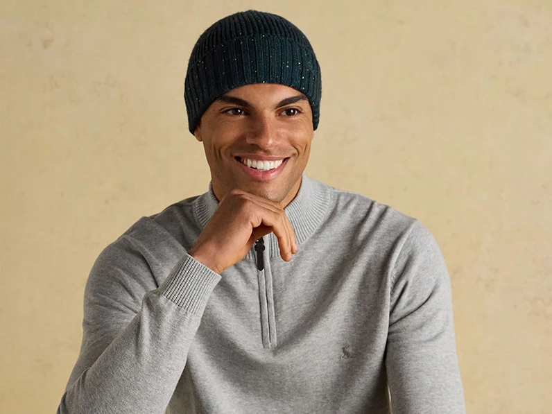 Man wearing navy beanie hat and a grey zip-neck sweater