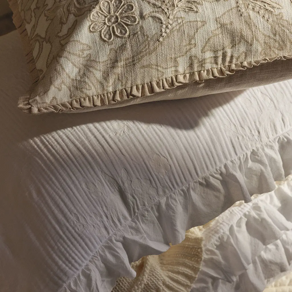 A pile of textured neutral cushions