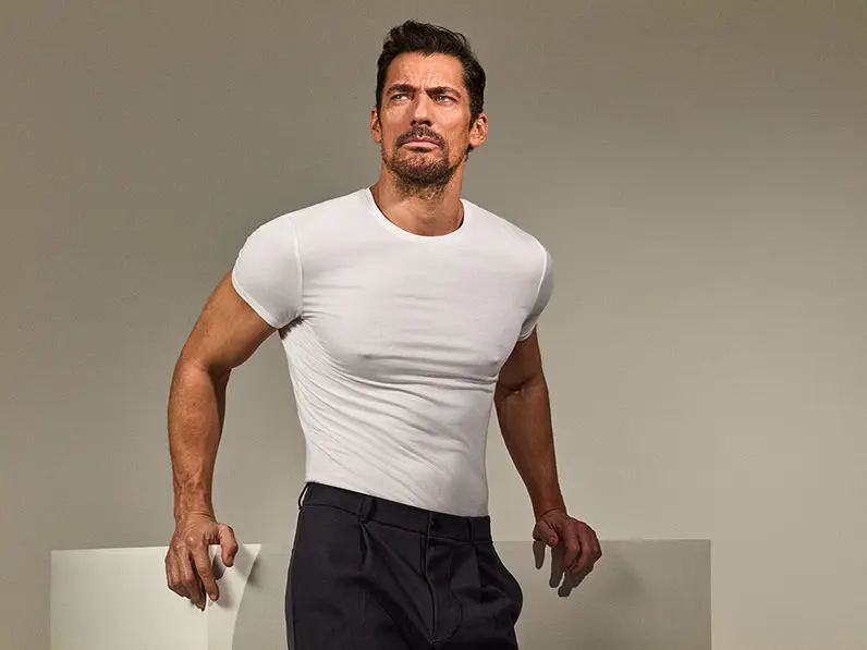 David Gandy wearing a white T-shirt and navy trousers