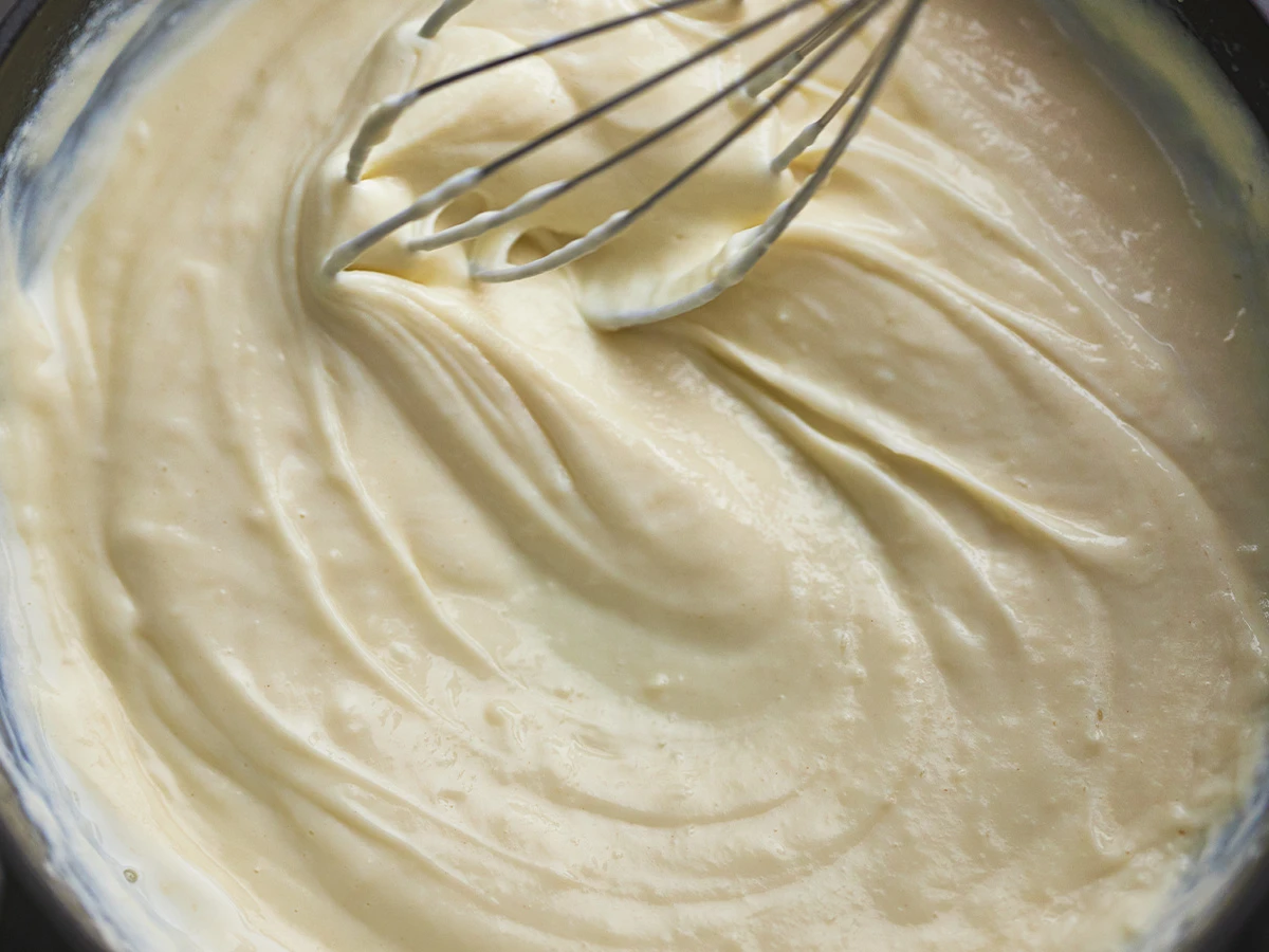 A pan of roux sauce being whisked 