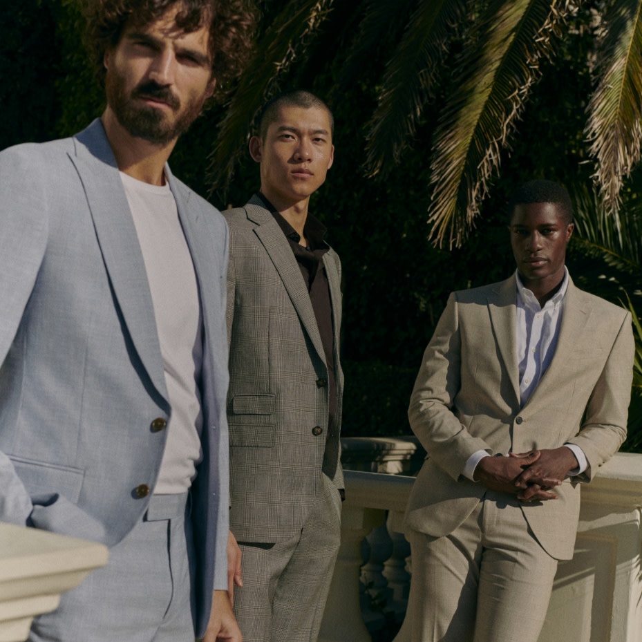 Group of men wearing suits in different colours. Shop men's suits 