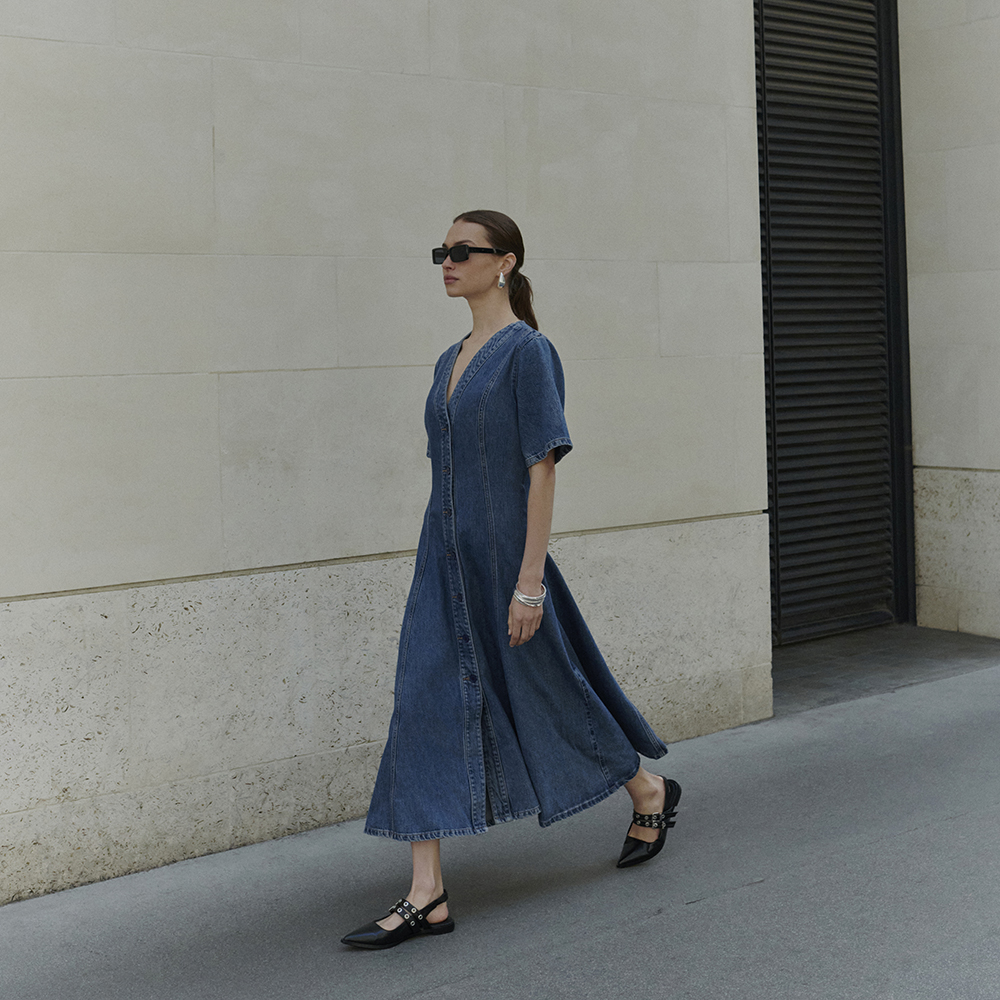 Woman wearing denim dress, sunglasses and slingback flats