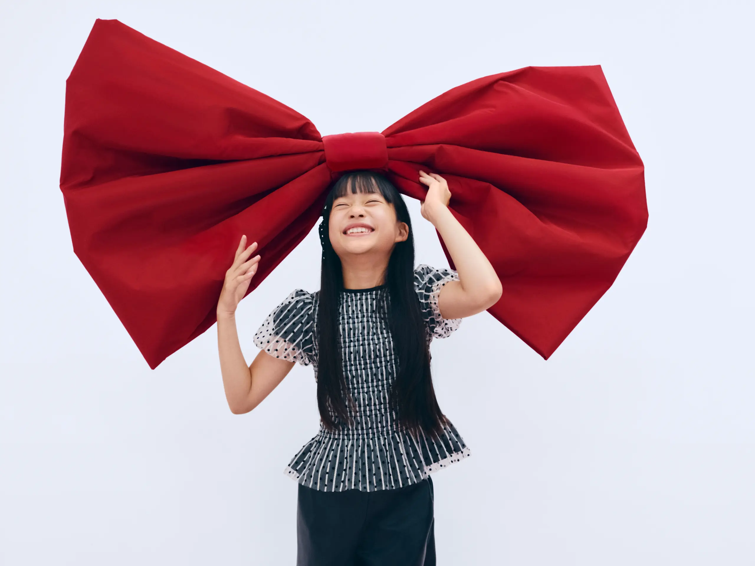 Image of young girl smiling and big red bow