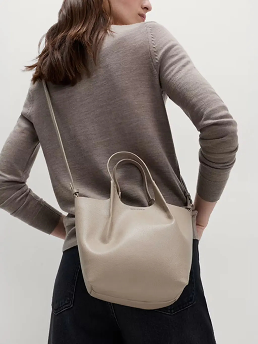 Woman wearing neutral faux-leather cross-body bag