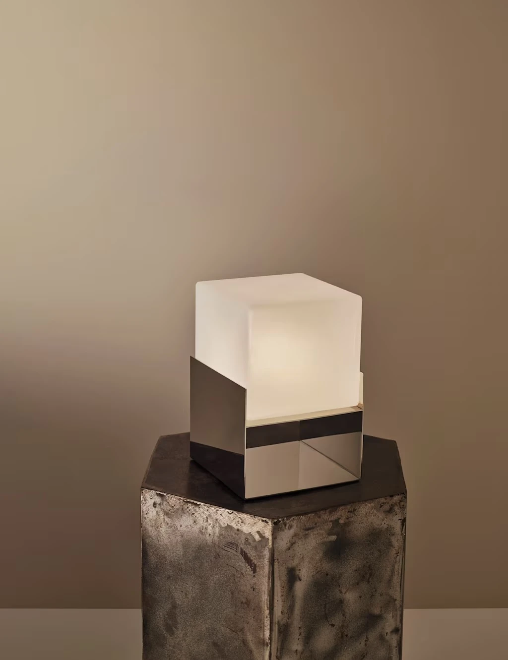 Square rechargeable lamp with an angular chrome base and white bulb.