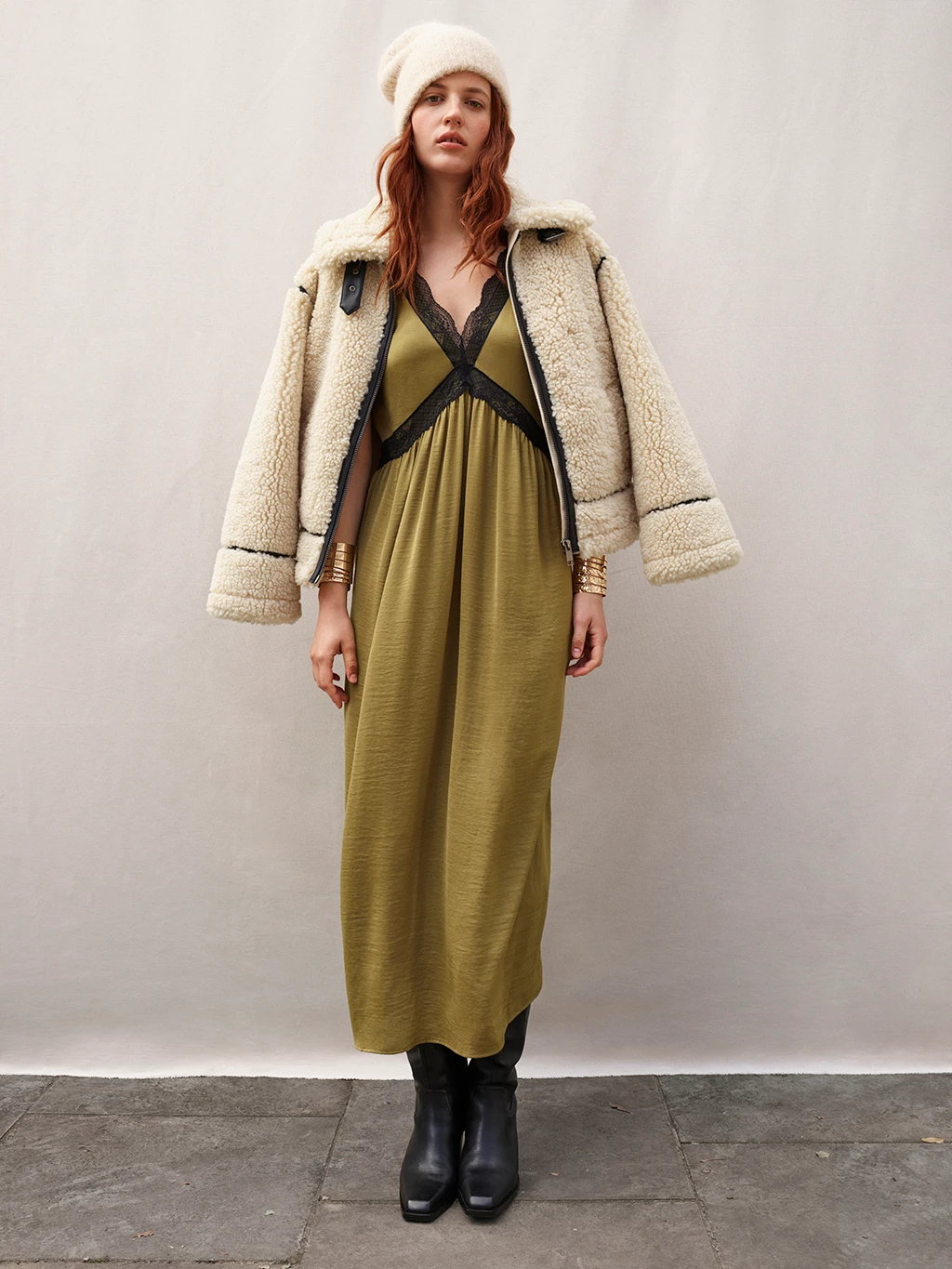Woman wearing a shearling aviator jacket over a slip dress