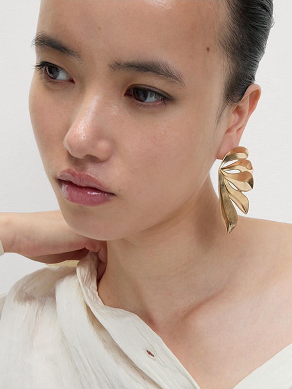Woman wearing gold oversized earrings