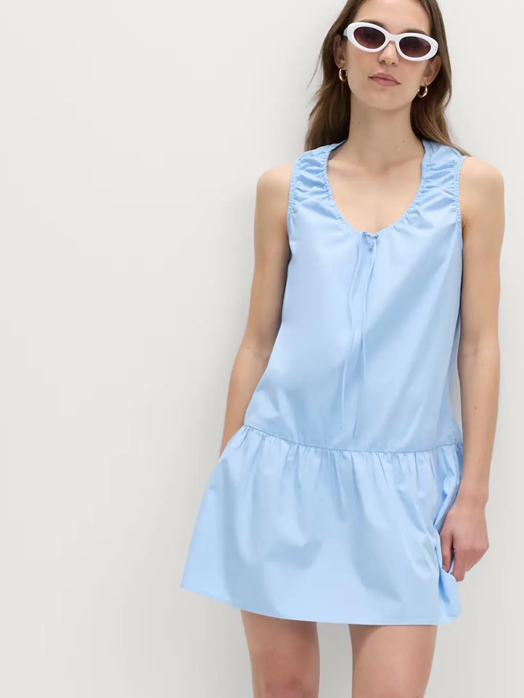 Woman wearing a blue mini dress with white sunglasses
