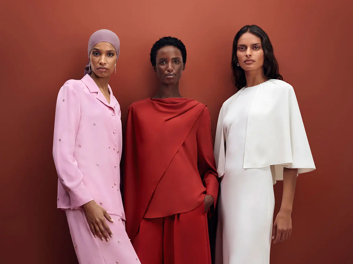 Three women wearing modest outfits in baby pink, red and white
