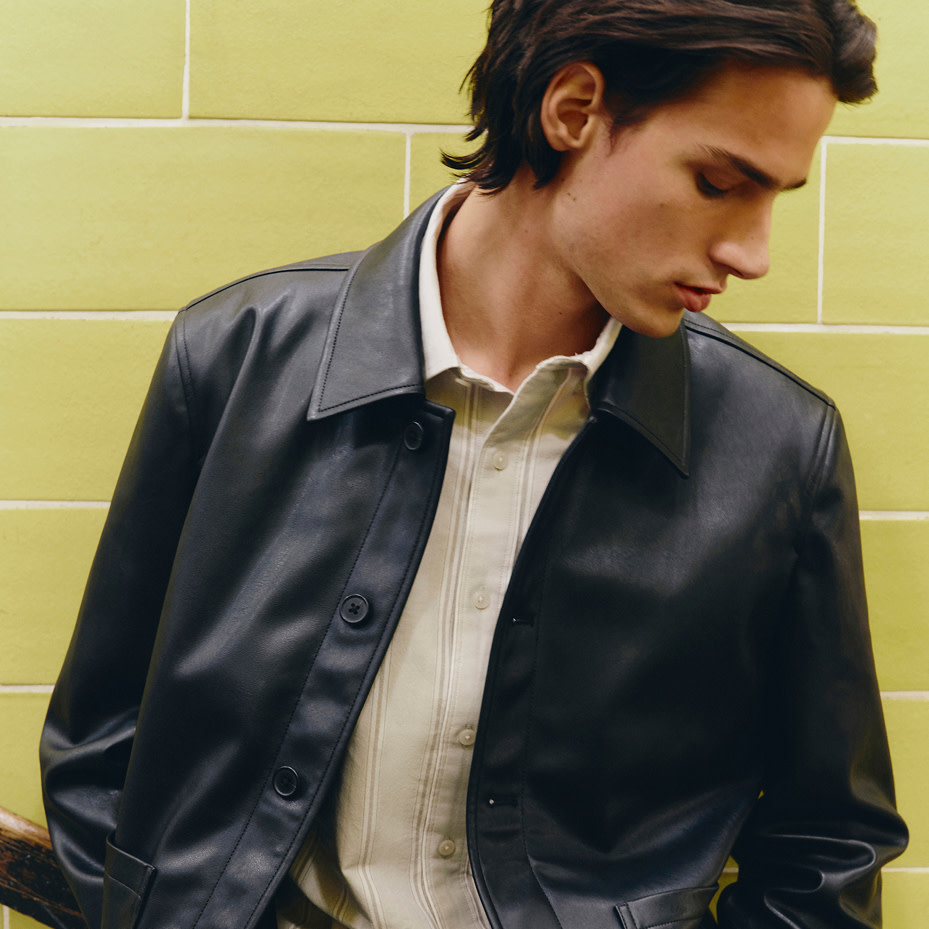 Man wearing black leather jacket over neutral shirt