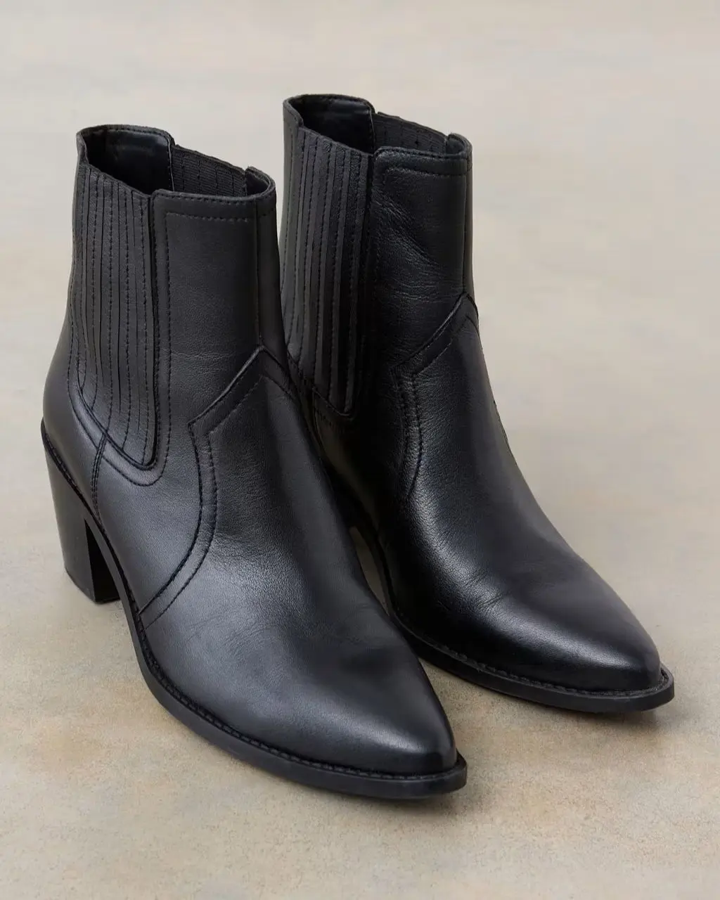 A pair of black cowboy boots sat on the floor