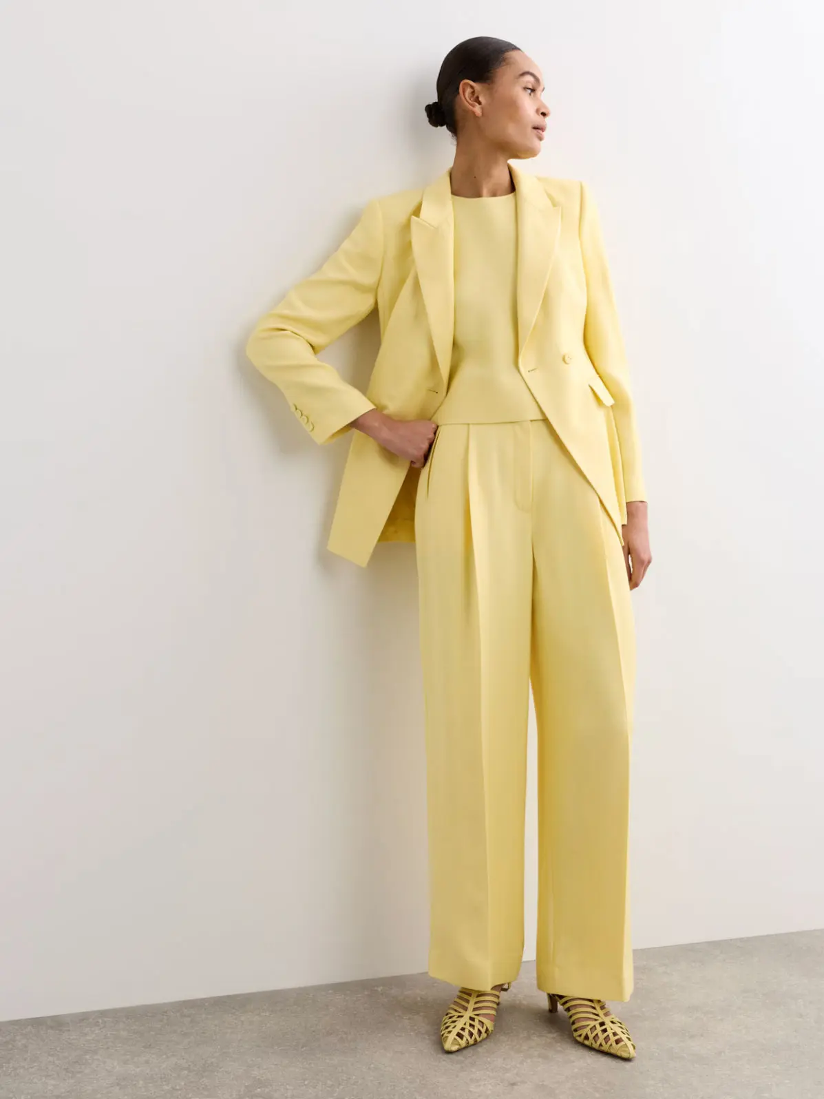 Woman wearing yellow suit and matching heels 