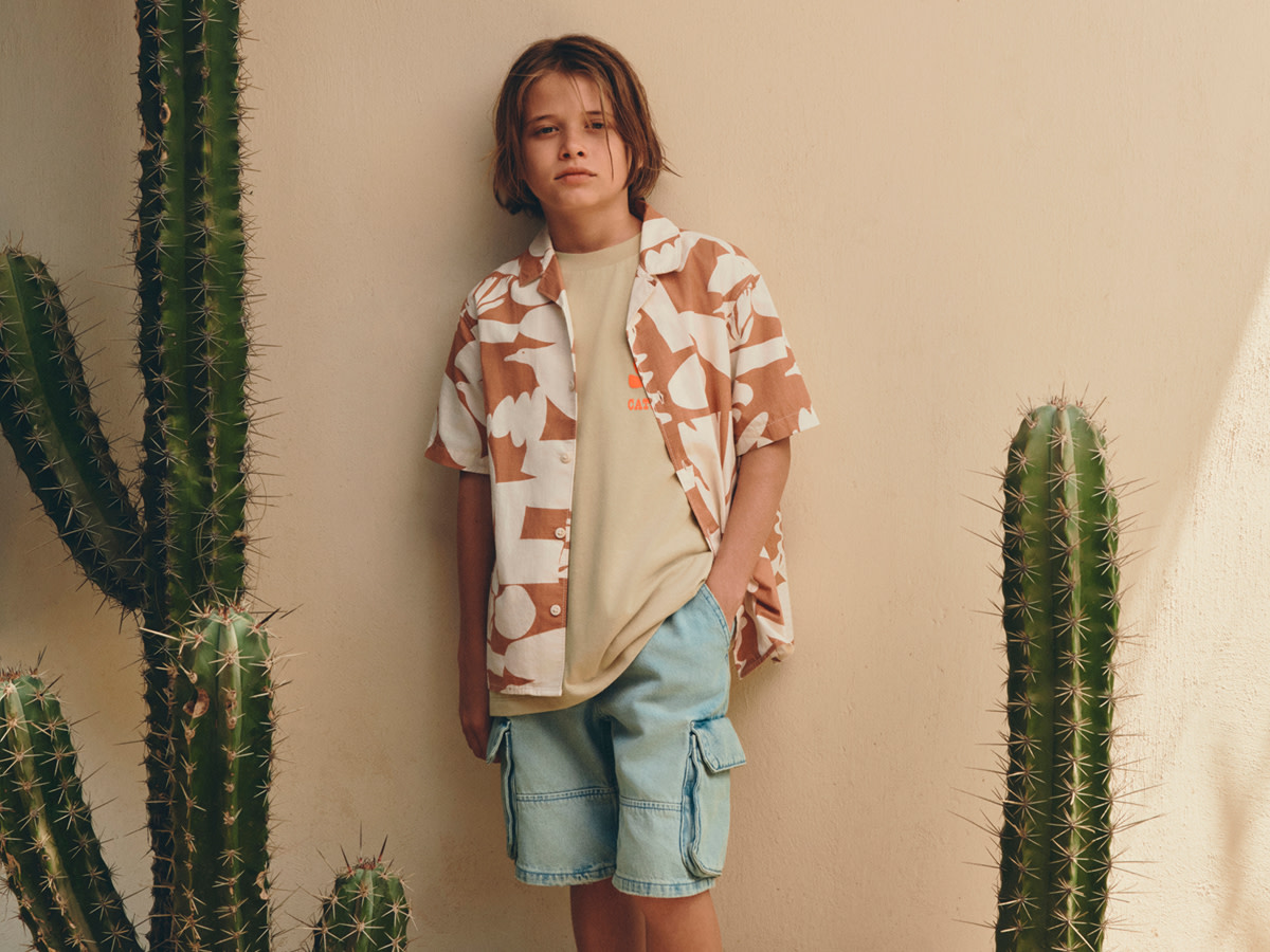 Boy in brown printed shirt and shorts