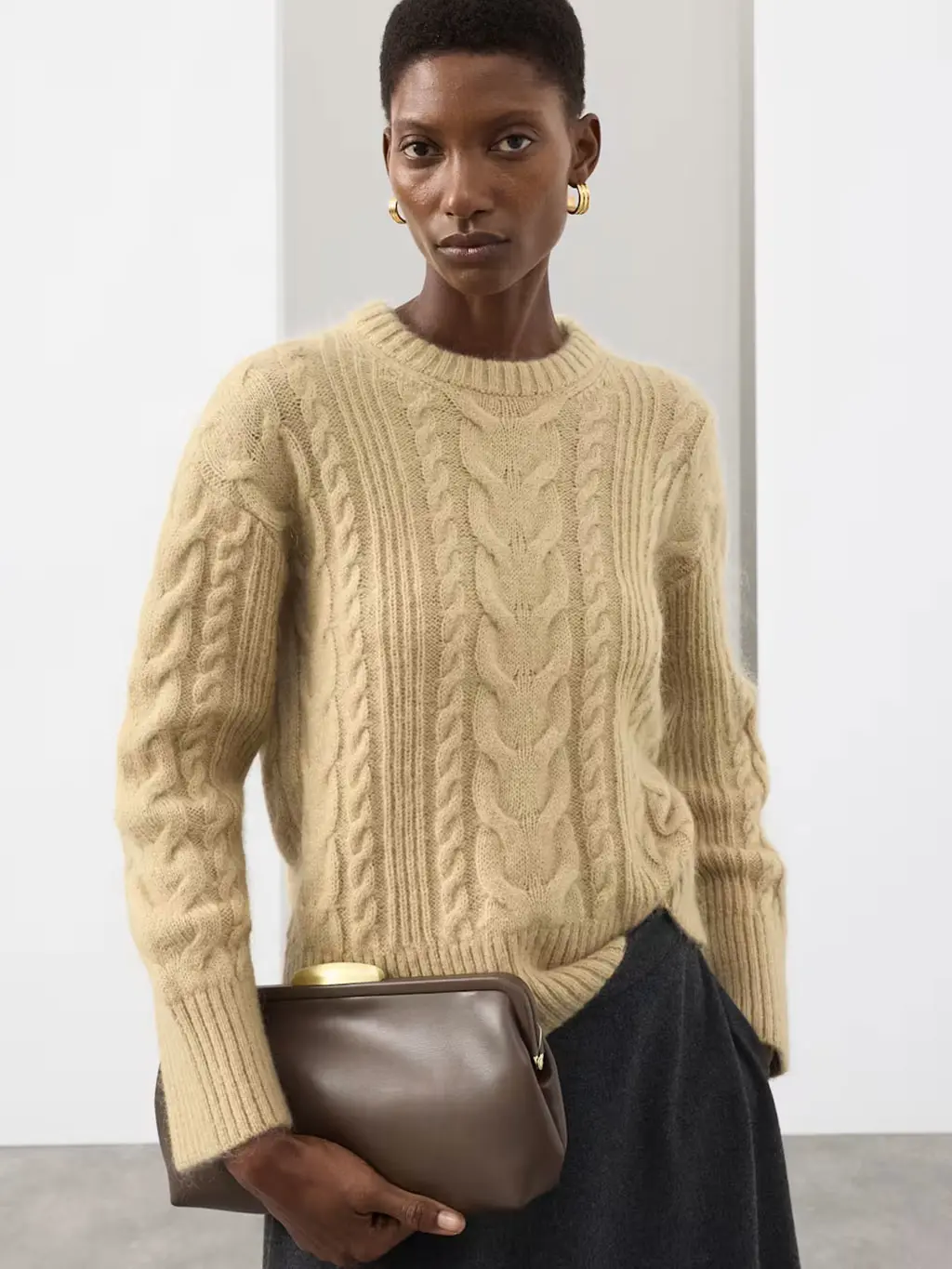 Woman wearing a beige cable-knit jumper