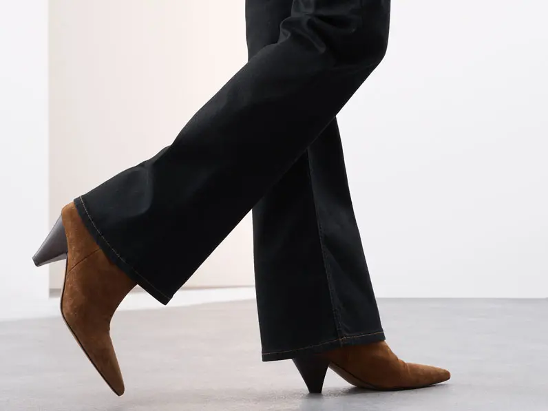 Woman wearing dark wash flared jeans and brown boots