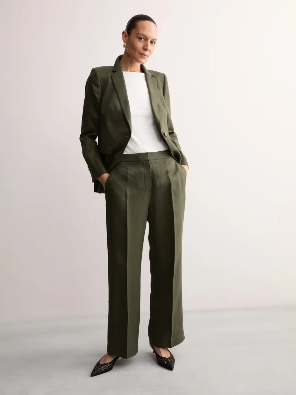 A woman wears khaki trousers with a matching blazer