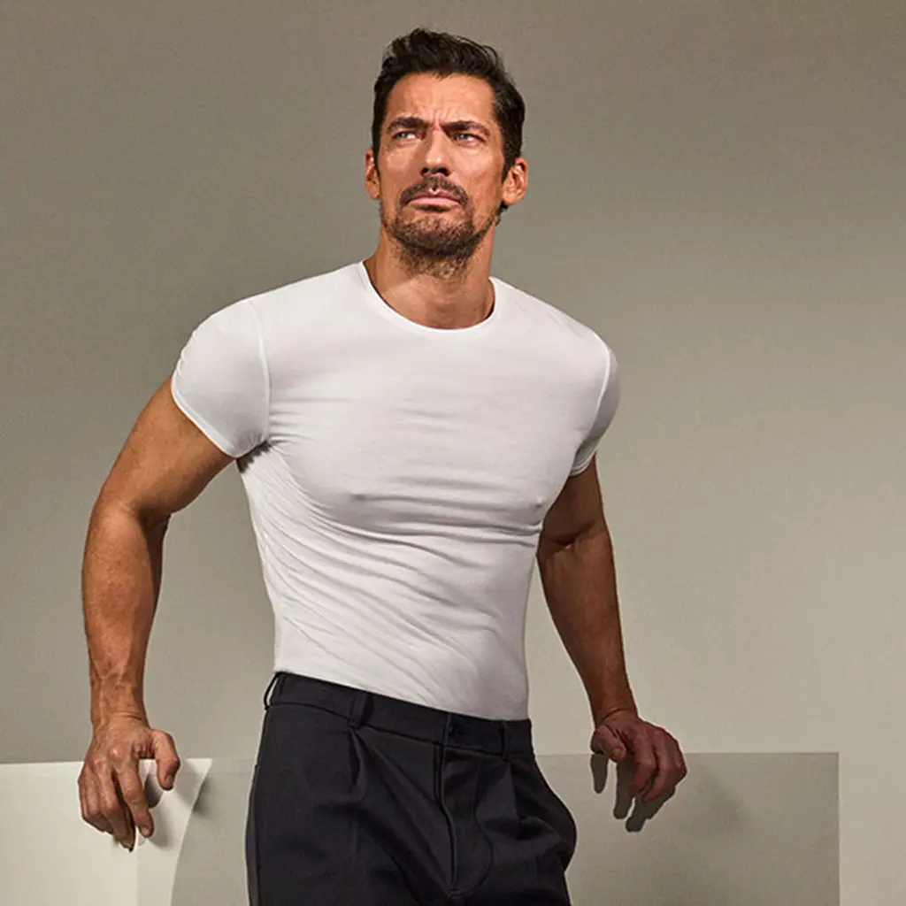 David Gandy wearing a white T-shirt with navy trousers