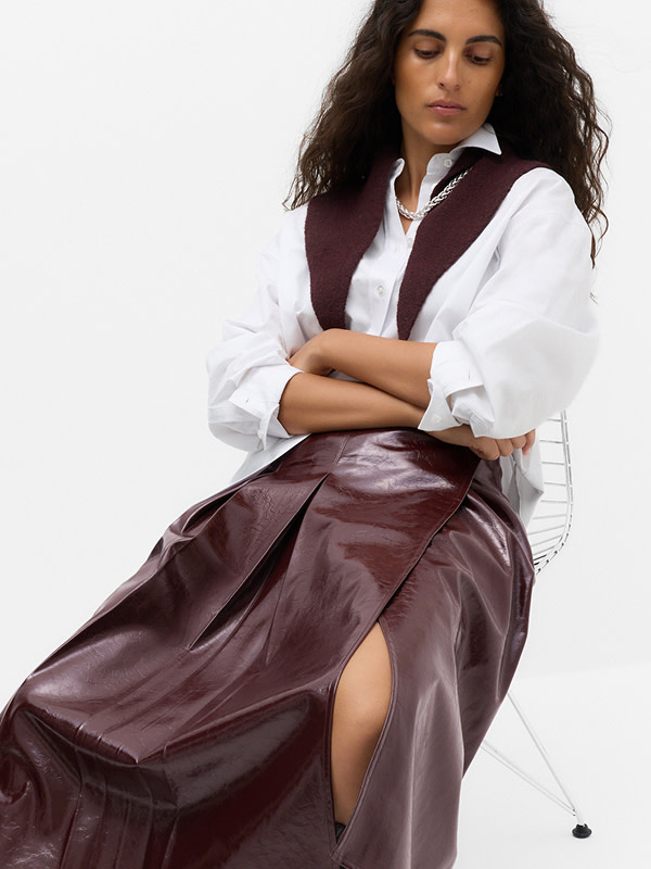 Woman wearing white shirt with burgundy leather skirt