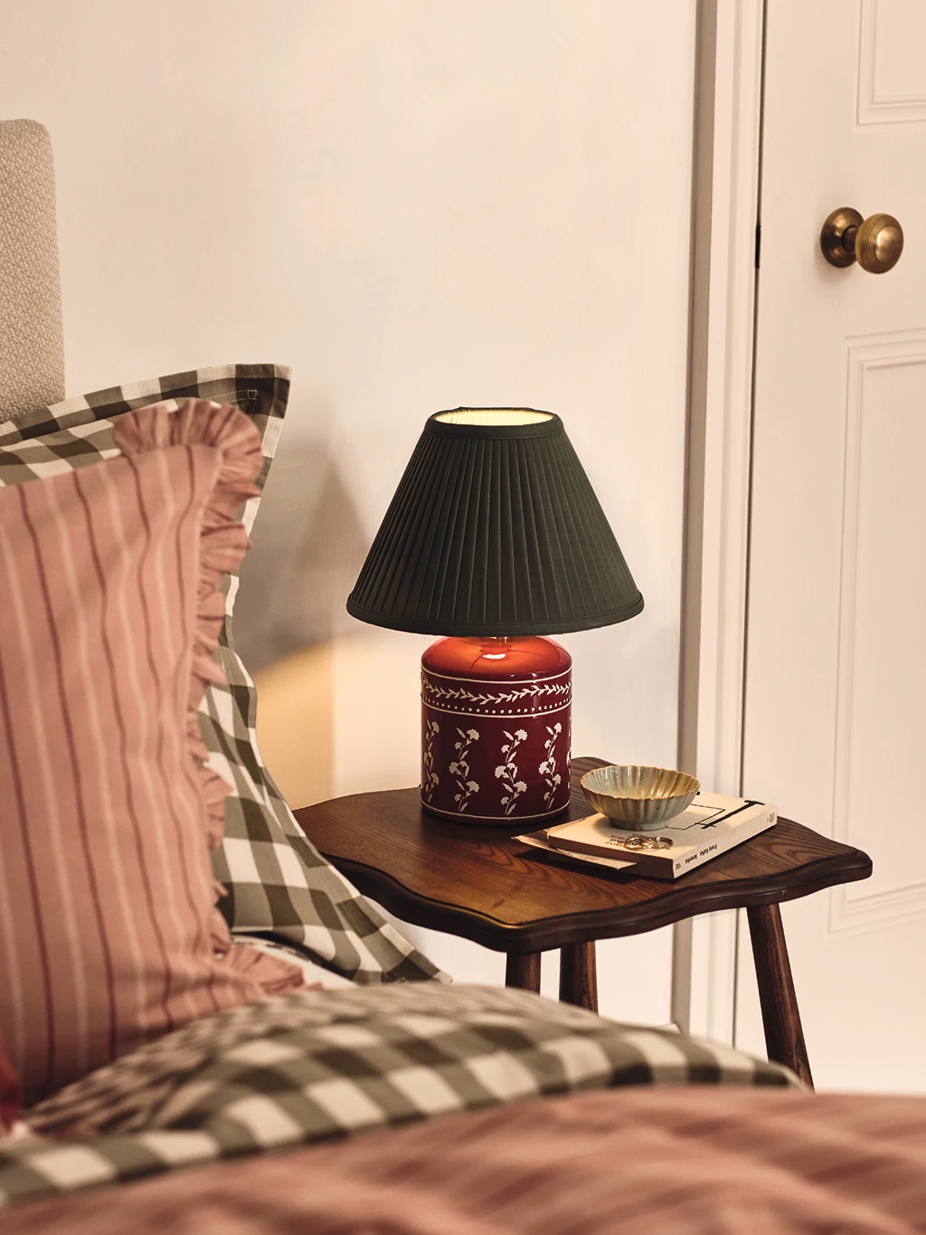 A green and orange ceramic bedside table with a lamp