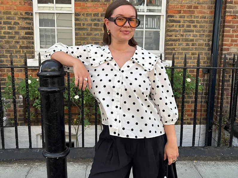 Woman in white polka top top and black shorts