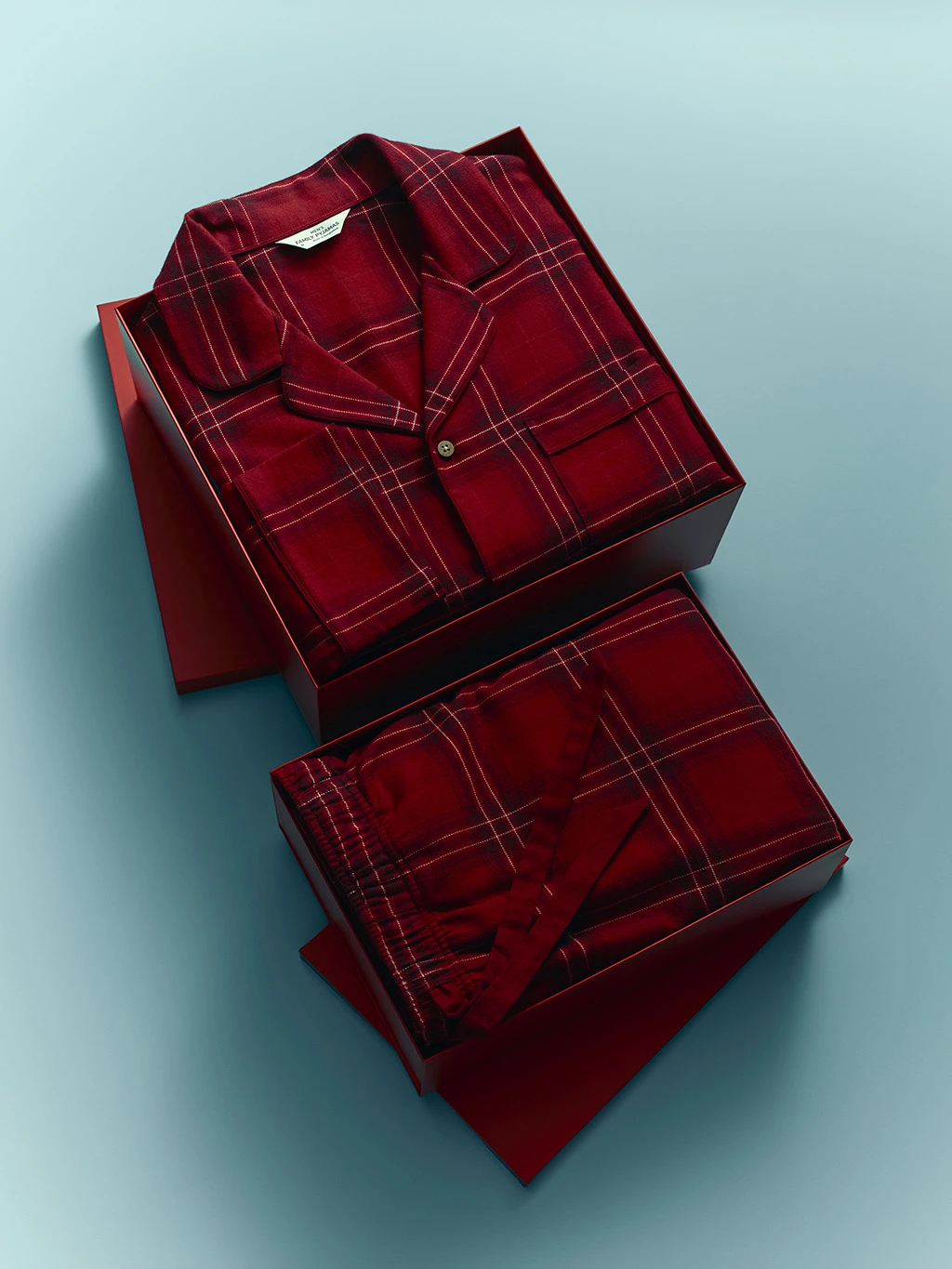 Red checked Christmas pyjamas folded in a red gift box.