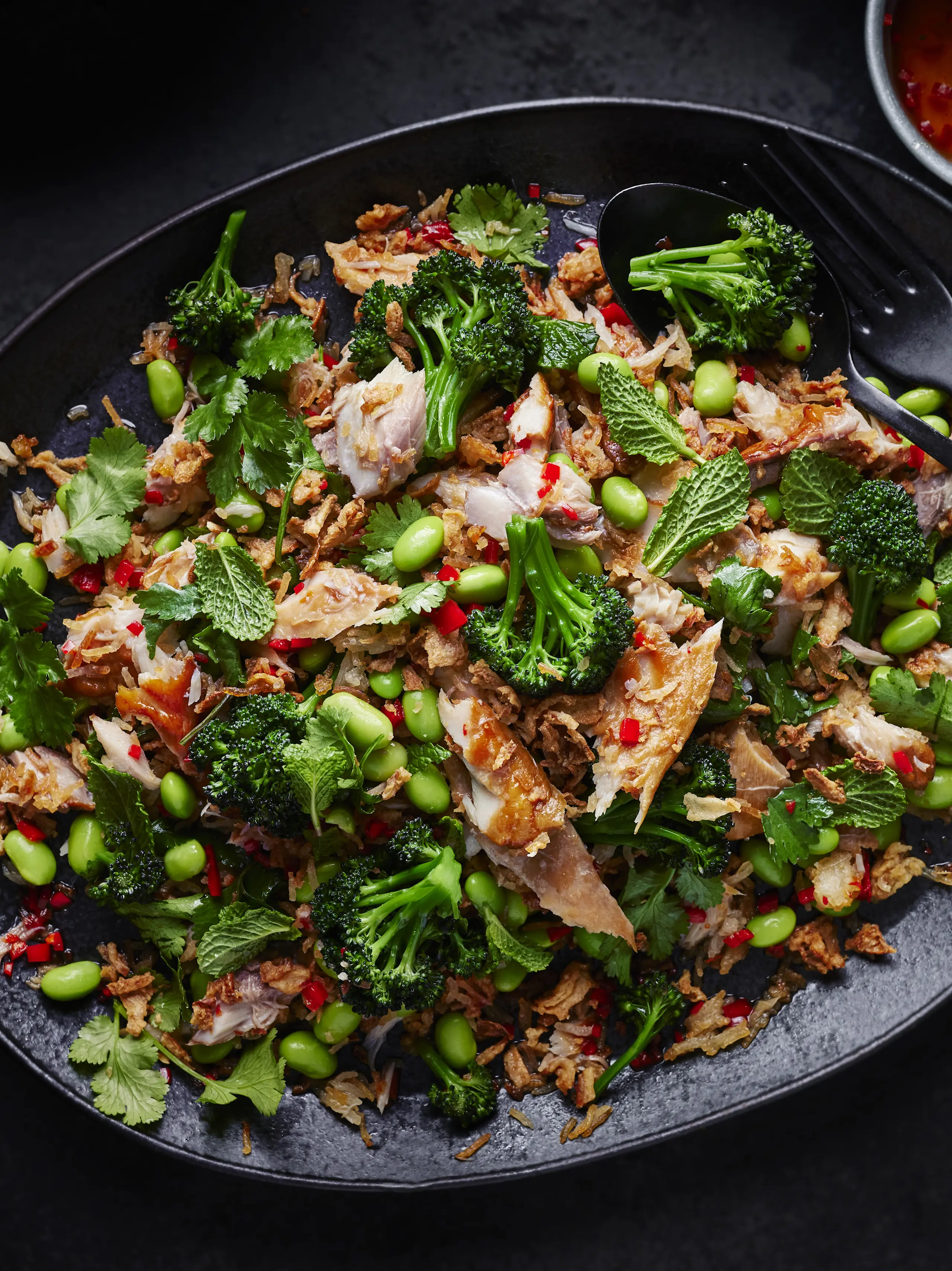 Smoked mackerel and crispy rice salad on black bowl