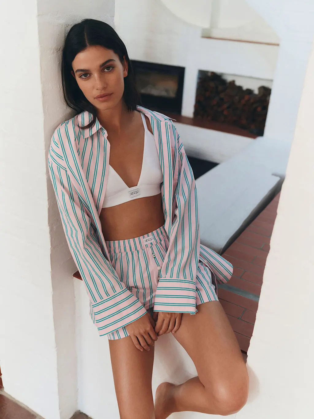 Woman wearing a striped shirt and short set with a white bralette
