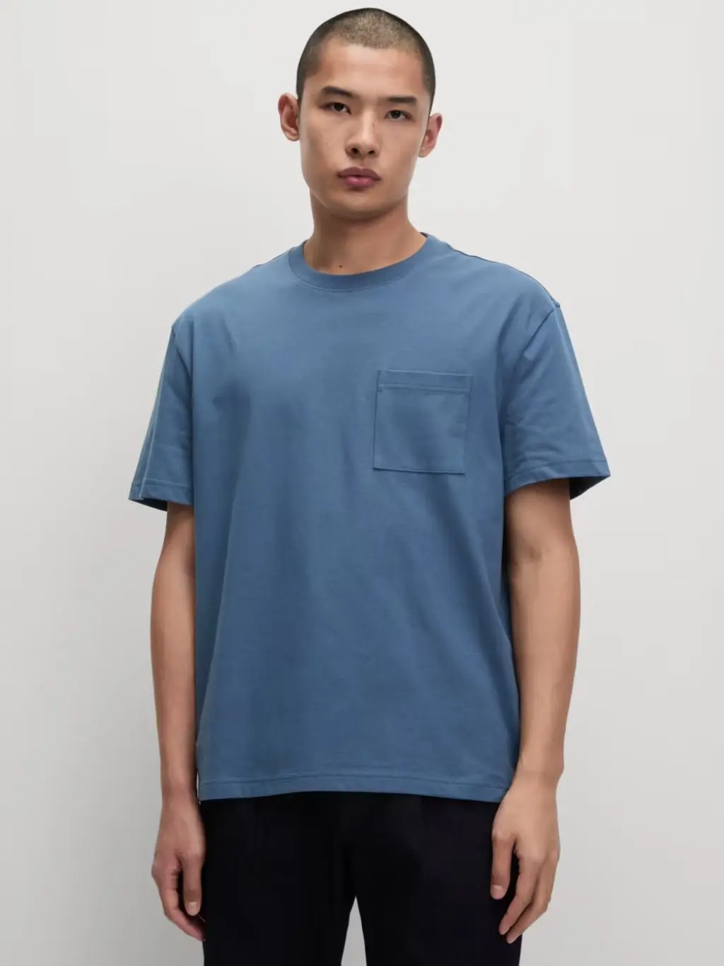 A man wears a dark blue relaxed fit T-shirt