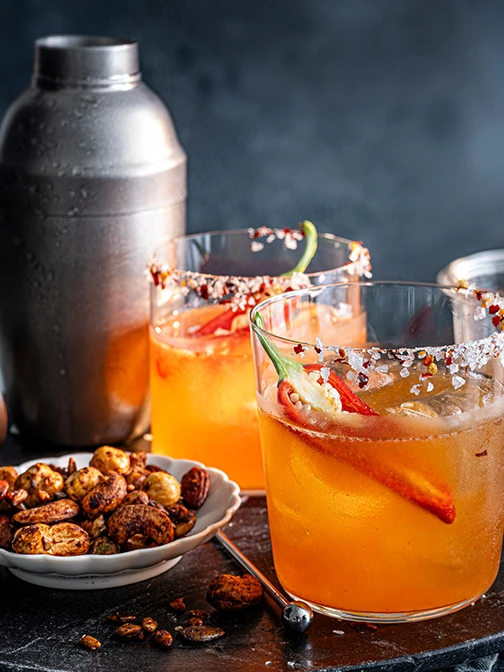 Two glasses of a spicy margarita with chilli pepper