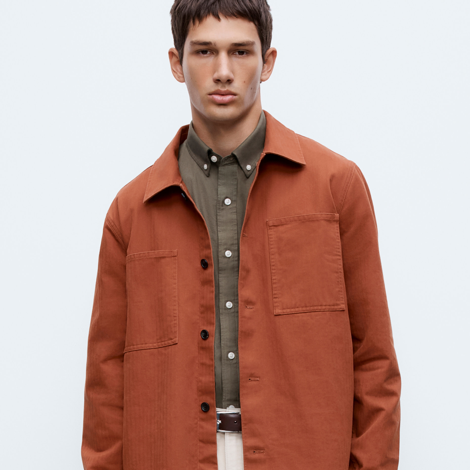 Man wearing terracotta jacket over olive green shirt