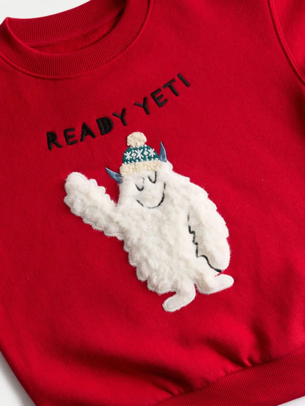 A close up of a read Yeti Christmas kids' jumper by M&S