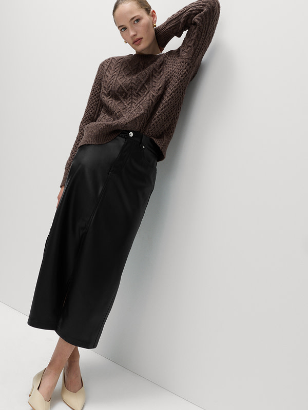 Woman wearing a brown top and a black faux leather midi skirt