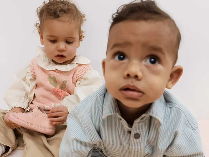 Little girl and little boy in front of white background