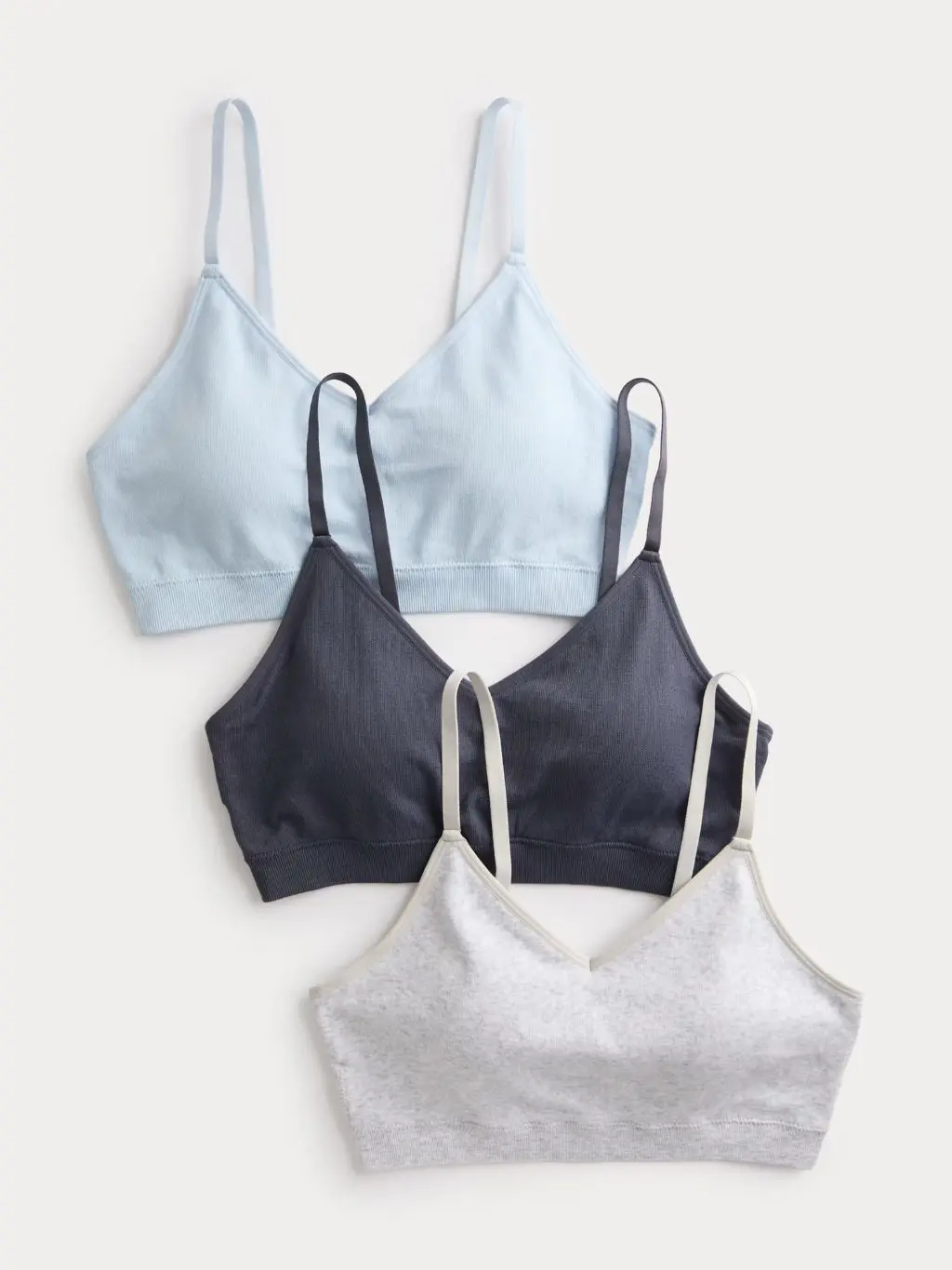 A three pack of pale blue, grey and dark blue M&S bralettes