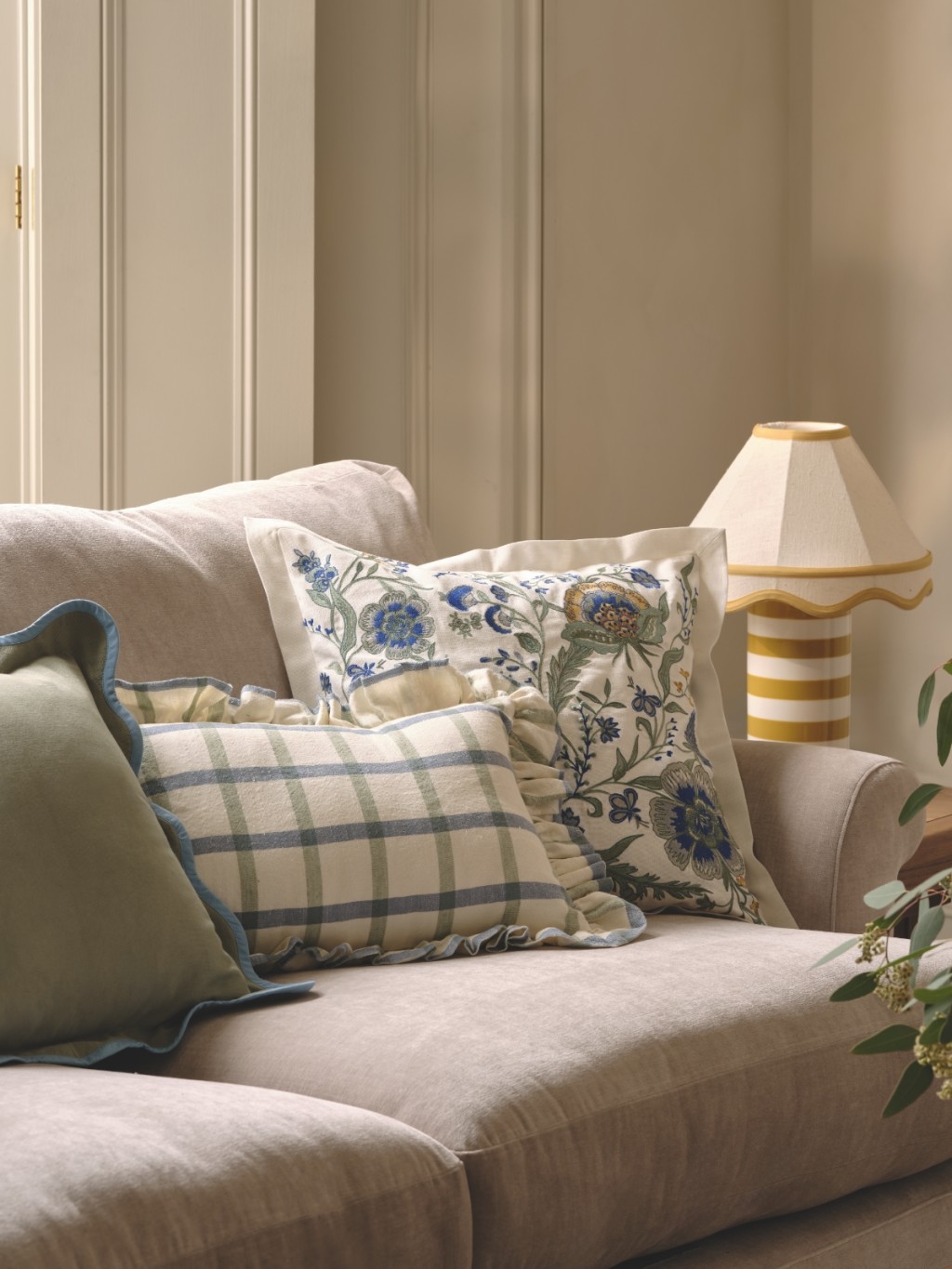 Light grey sofa with cushions in plain, checked and floral designs. Shop the Classic Reimagined trend